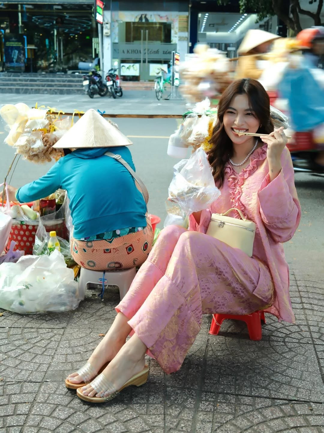 Giữa không gian vỉa hè quen thuộc, người đẹp sinh năm 1996 nổi bật bởi nụ cười tươi, ánh mắt hiền và thần thái thanh lịch.