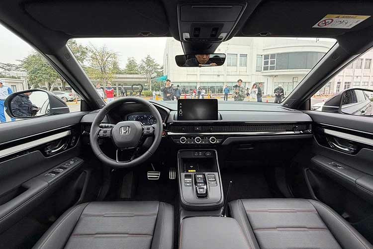 Bên trong, điểm nhấn thuộc về hệ thống chuyển số bằng nút bấm thay thế cần số truyền thống, giúp nội thất gọn gàng và hiện đại hơn. Honda bổ sung màn hình hiển thị trên kính lái (HUD) trên bản e:HEV RS, đồng thời điều chỉnh họa tiết ghế bọc da với đường chỉ đỏ điểm xuyết cùng logo RS dập nổi.