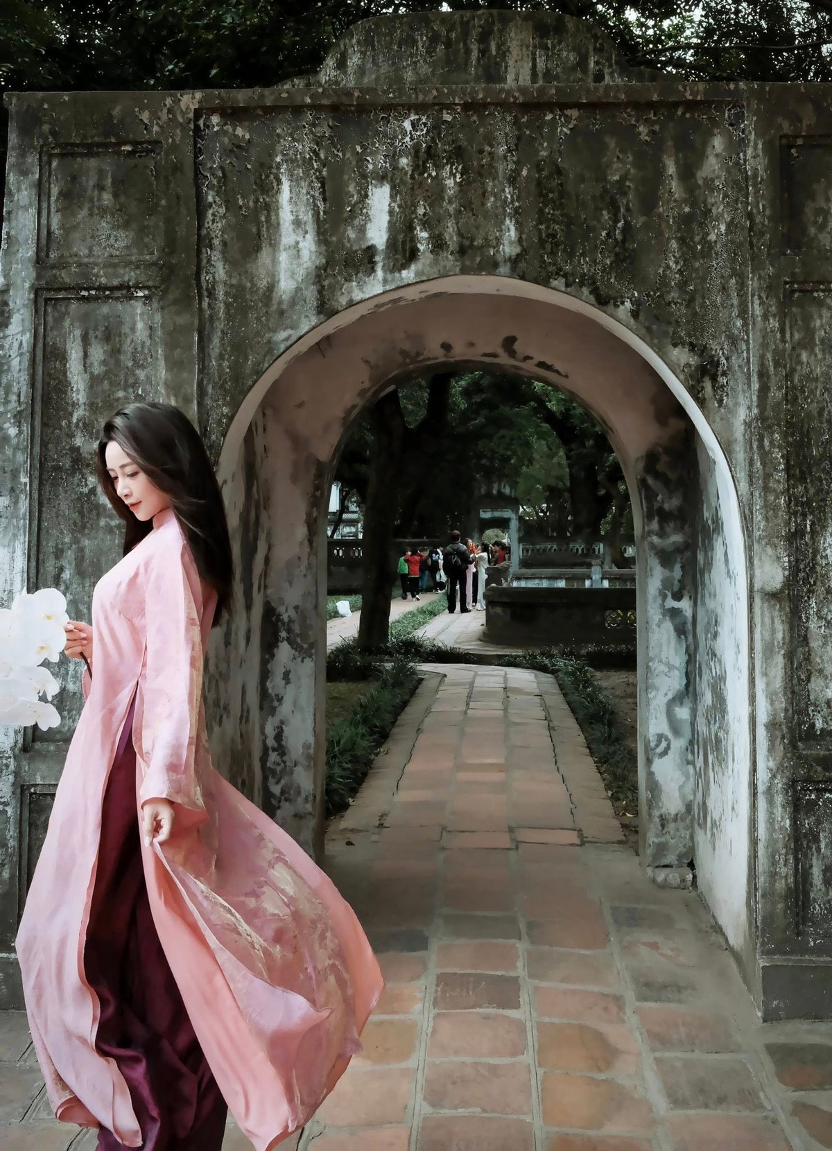 Trong bộ áo dài dáng suông truyền thống, gam hồng phấn nhẹ nhàng tôn lên làn da trắng mịn và vóc dáng thon gọn của Võ Nhật Linh. Thiết kế tối giản, không quá cầu kỳ nhưng lại làm nổi bật thần thái nữ tính, kín đáo mà vẫn cuốn hút.