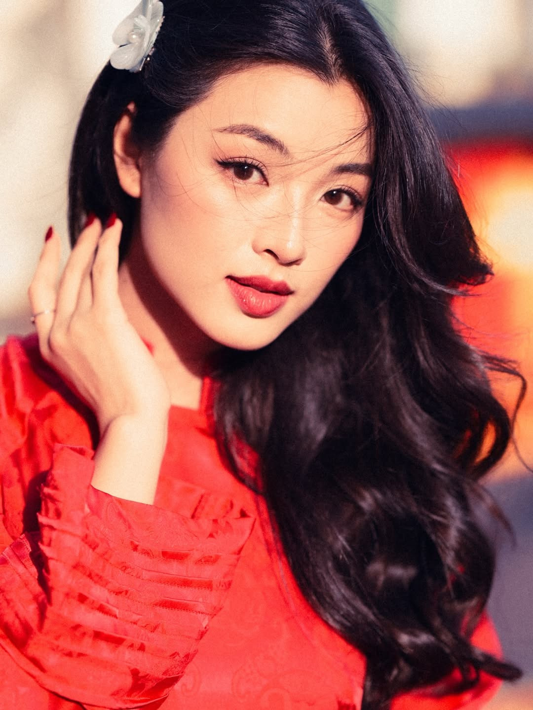 Trong loạt hình dạo phố, Phạm Nguyễn Lan Thy lựa chọn áo dài đỏ truyền thống với phom dáng tối giản nhưng tinh tế. Sắc đỏ nổi bật giúp tôn lên làn da trắng mịn và những đường nét gương mặt thanh tú của cô.