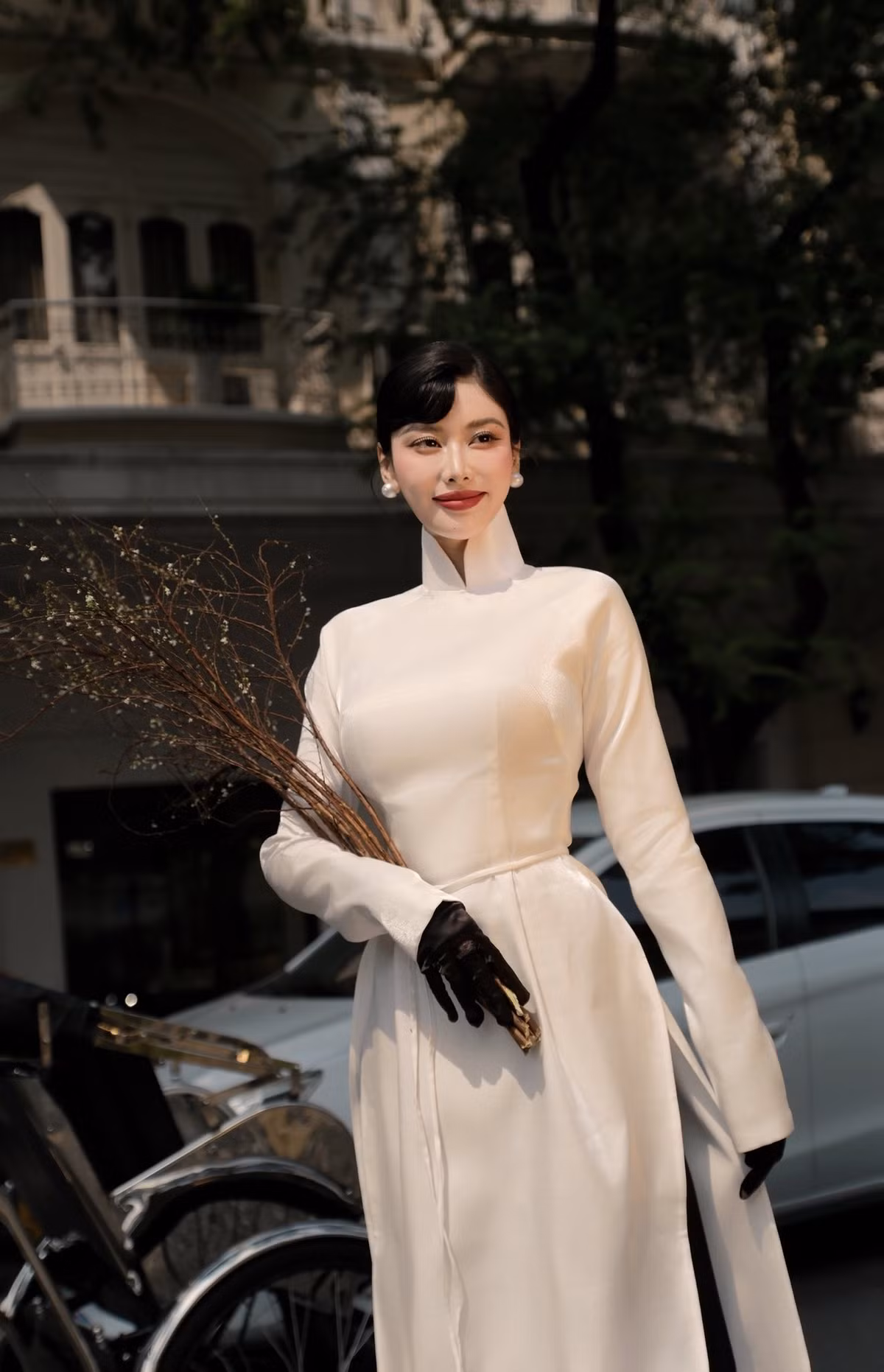 Điểm nhấn là cách Thái Ngọc San kết hợp áo dài với găng tay đen, phụ kiện ngọc trai và lối tạo dáng mang hơi hướng cổ điển, khiến bộ ảnh mang màu sắc nghệ thuật rõ nét.