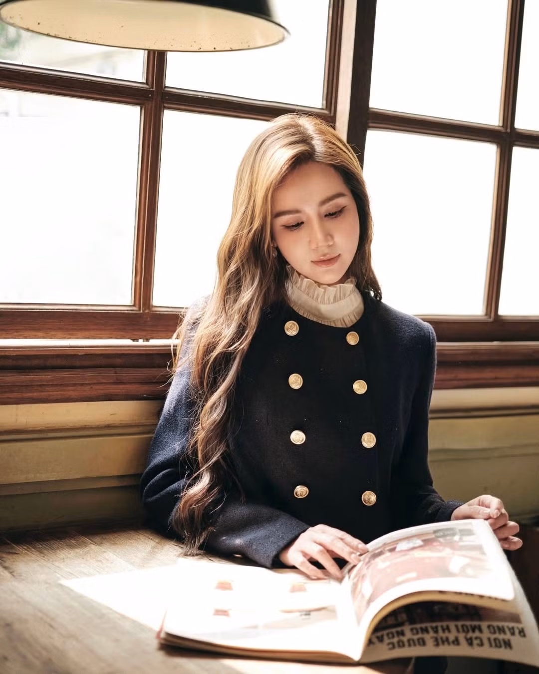 Khoảnh khắc Huyền Lizzie ngồi trong một quán cà phê nhỏ, đón ánh nắng dịu buổi sáng, tạo nên một khung hình mang đậm chất điện ảnh, tinh tế và vô cùng cuốn hút.