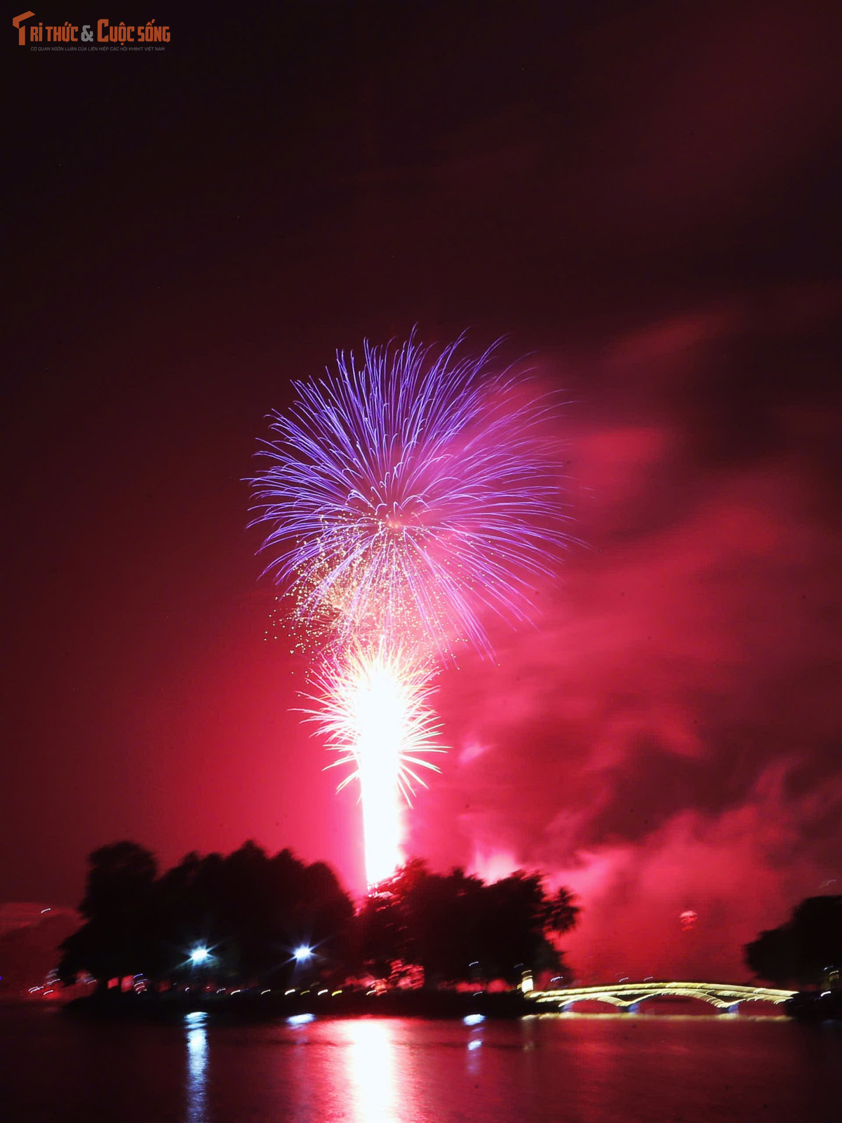 Đúng 23h45 phút, bầu trời Hà Nội bừng sáng với màn pháo hoa rực rỡ kéo dài nhiều phút liền. Những chùm pháo hoa đa sắc liên tiếp bung nở, phản chiếu xuống mặt hồ trong công viên, tạo nên khung cảnh lung linh, huyền ảo.
