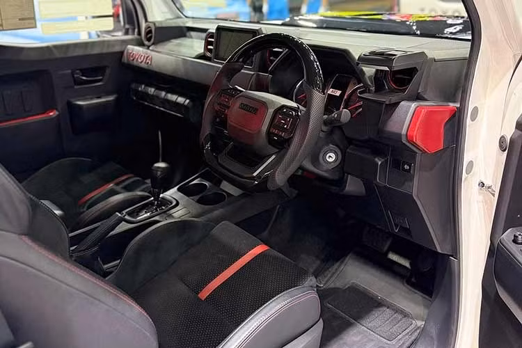 Không gian nội thất cũng được nâng cấp với vô-lăng mới lấy từ Hilux thế hệ mới, màn hình giải trí trung tâm và các chi tiết trang trí màu đỏ trên bảng táp-lô. Ghế ngồi thể thao bọc da kết hợp Alcantara mang lại cảm giác cao cấp hơn so với phiên bản tiêu chuẩn.