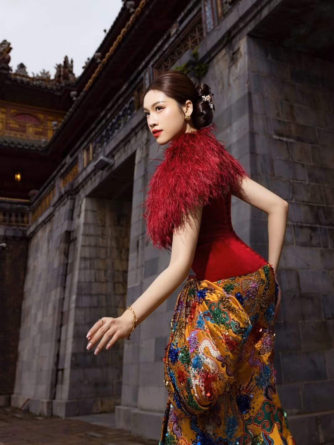Diện thiết kế đỏ nổi bật với phần cổ lông vũ mềm mại kết hợp chân váy họa tiết rồng phượng sắc vàng rực rỡ, Thanh Thanh Huyền toát lên vẻ đẹp vừa hiện đại vừa gợi nhớ tinh thần hoàng gia Á Đông.