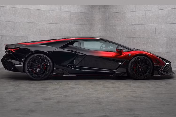 Phần đầu Lamborghini Revuelto Mansory Initiate táo bạo hơn nhờ vào thiết kế khí động học cùng nhiều đường cắt xẻ, kết hợp logo Mansory phát sáng ở nắp capo. Thân xe có điểm nhấn là màu sơn phối đỏ - đen cùng hiệu ứng Ombré.