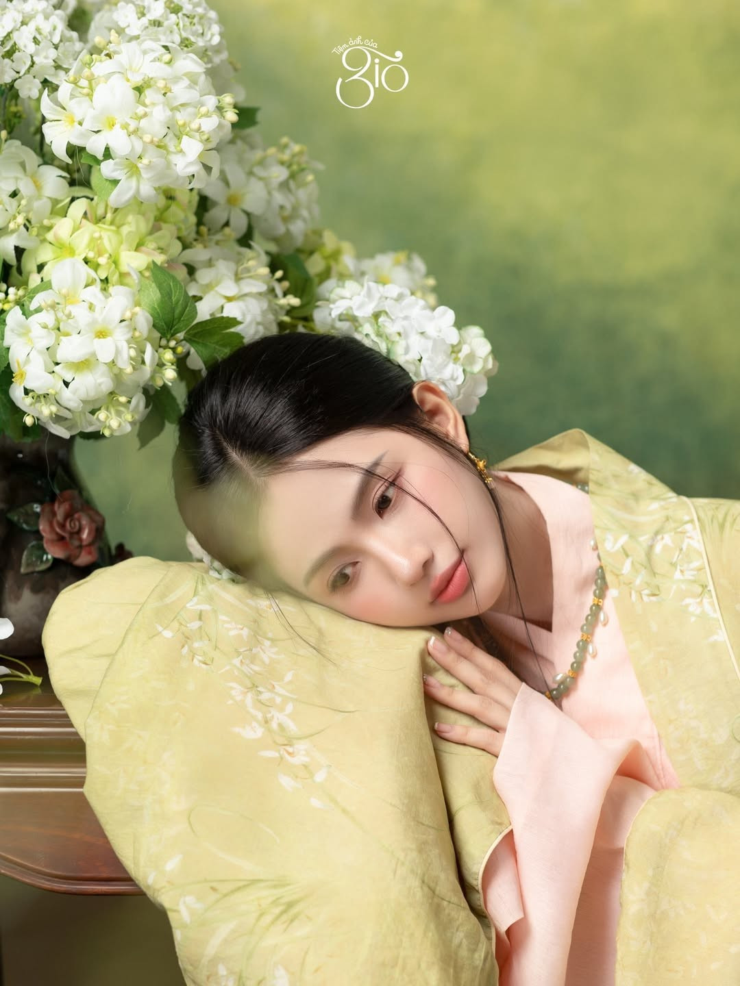 Trong bộ Việt phục mang gam màu nhã nhặn, Quỳnh Anh ghi điểm bởi sự hài hòa giữa trang phục, bối cảnh và biểu cảm. Ánh sáng mềm mại tôn lên làn da trắng mịn, gương mặt bầu bĩnh cùng đôi mắt to tròn, trong veo.