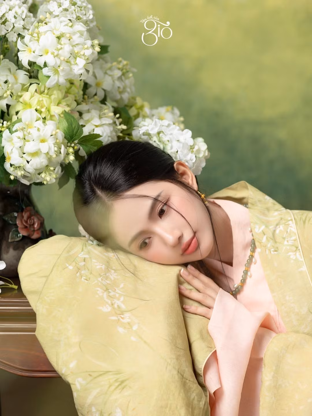 Trong bộ Việt phục mang gam màu nhã nhặn, Quỳnh Anh ghi điểm bởi sự hài hòa giữa trang phục, bối cảnh và biểu cảm. Ánh sáng mềm mại tôn lên làn da trắng mịn, gương mặt bầu bĩnh cùng đôi mắt to tròn, trong veo.