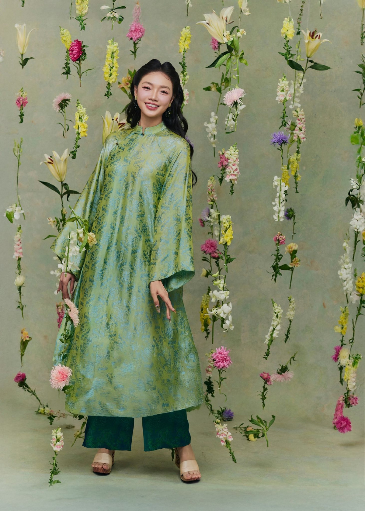 Sự kết hợp giữa sắc hoa pastel và nền xanh trầm tạo nên tổng thể hài hòa, giúp Dương Thu Thảo nổi bật mà không hề bị “lấn át”. Mỗi khung hình đều mang màu sắc hội họa, gợi liên tưởng đến vẻ đẹp của người phụ nữ Á Đông trong những bức tranh cổ.