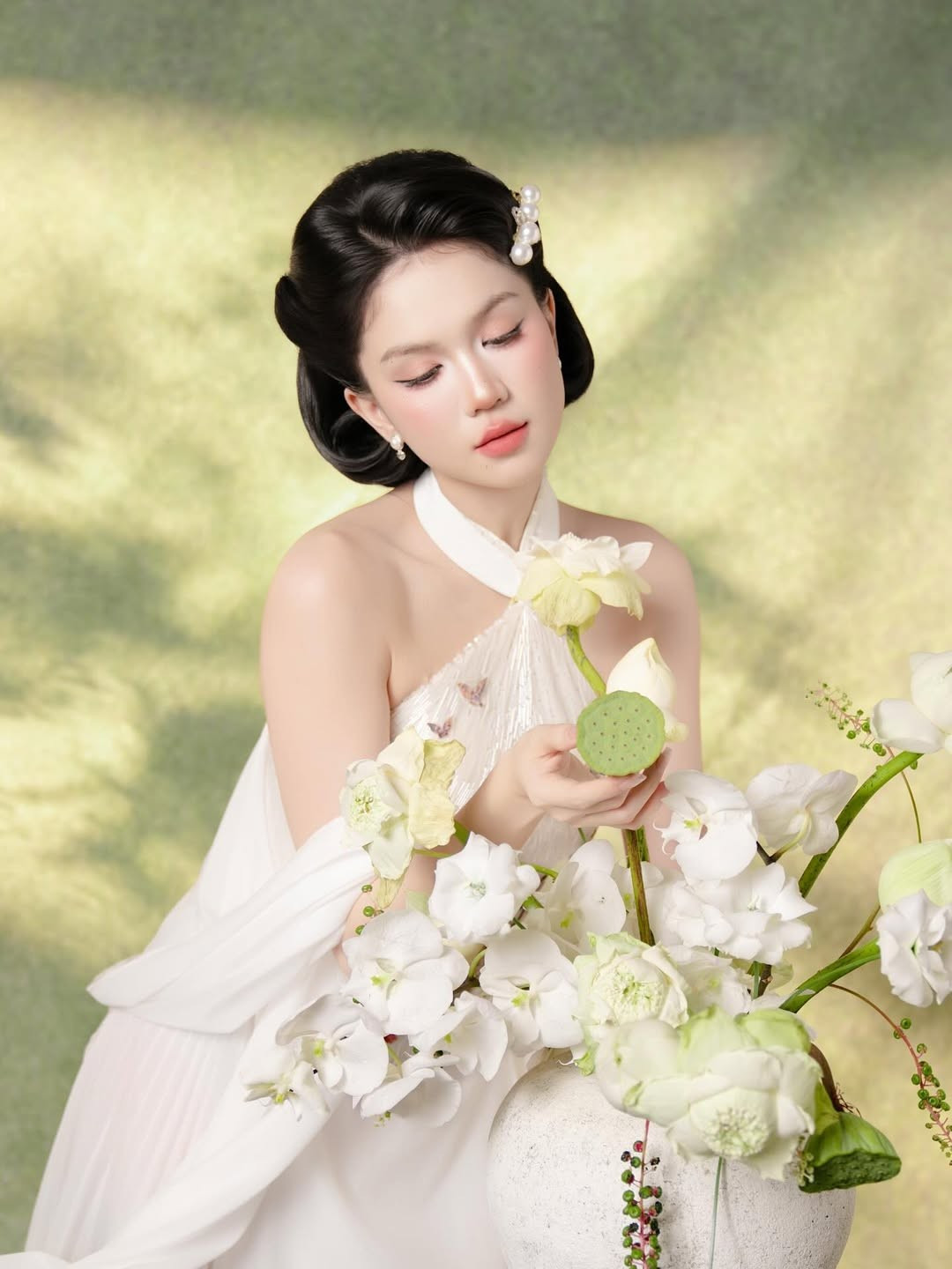 Sen trắng, loài hoa tượng trưng cho sự thanh cao, thoát tục, dường như đã làm nổi bật vẻ đẹp dịu dàng, tĩnh lặng hiếm thấy của Ngọc Trinh.