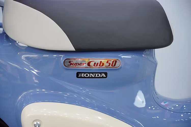 Thân xe được điểm xuyết bởi các chi tiết sơn bạc và mạ chrome, làm nổi bật phong cách cổ điển huyền thoại Honda Cub đã có từ hàng chục năm qua.