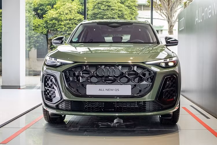 Tuy nhiên, lưới tản nhiệt trên mẫu xe SUV hạng sang Audi Q5 2026 được thiết kế thể thao và rộng hơn trước. Nằm hai bên lưới tản nhiệt là khe gió nằm dọc mới. Trong khi đó, bên dưới lưới tản nhiệt là hốc gió trung tâm tích hợp cảm biến. Tiếp theo là cụm đèn pha Matrix LED sắc sảo hơn và đèn hậu OLED kỹ thuật số thế hệ thứ hai với đồ họa 3D.