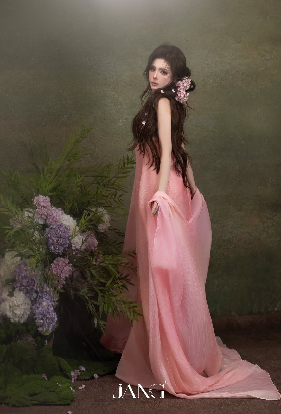 Cận cảnh gương mặt, Lilly Luta ghi điểm với lớp trang điểm trong veo, tông hồng ngọt ngào, đôi môi căng mọng và sống mũi thanh tú. Mái tóc dài uốn nhẹ, điểm xuyết những cánh hoa nhỏ càng làm tăng cảm giác mong manh, nữ tính.