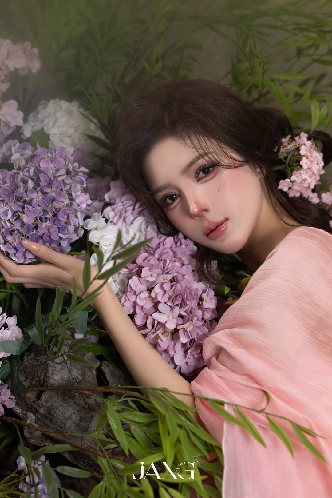 Trong bộ ảnh, Lilly Luta xuất hiện giữa không gian ngập tràn hoa lá, ánh sáng được xử lý mềm mại, tôn trọn làn da trắng mịn và đường nét gương mặt hài hòa.