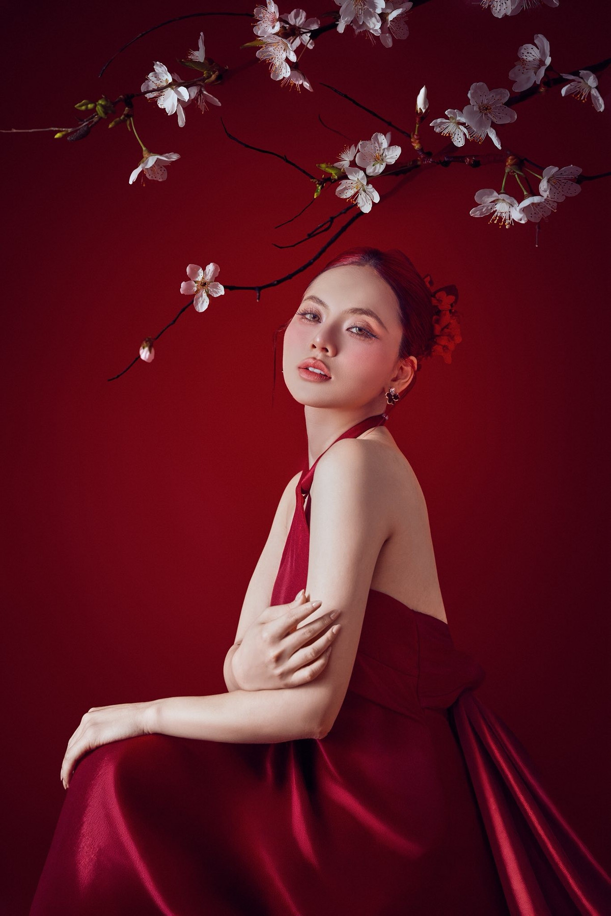 Không chỉ gây ấn tượng bởi trang phục, Ngô Lan Hương còn ghi điểm với phong cách trang điểm sắc sảo nhưng không quá nặng nề. Làn da mịn màng, đôi mắt được nhấn nhá tinh tế cùng sắc son đỏ hài hòa với tổng thể trang phục giúp nữ ca sĩ toát lên vẻ cuốn hút rất riêng. Kiểu tóc búi gọn, điểm xuyết phụ kiện đỏ đồng điệu càng làm nổi bật thần thái tự tin, trưởng thành của cô trong lần xuất hiện này.