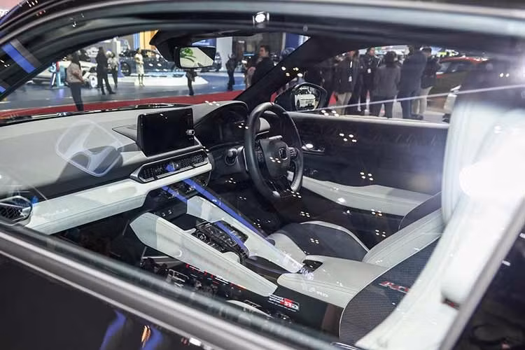 Bên trong khoang lái, Honda Prelude 2026 thừa hưởng nhiều nét tương đồng với Civic như bảng đồng hồ kỹ thuật số 10,2 inch và màn hình giải trí 9 inch hỗ trợ kết nối không dây. Tuy nhiên, điểm nhấn khác biệt nằm ở hệ thống ghế ngồi với thiết kế đệm bất đối xứng lần đầu tiên xuất hiện.