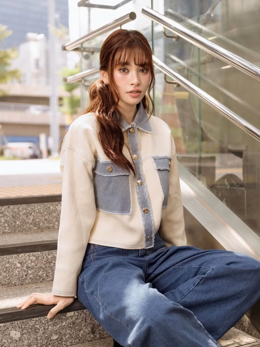 Tiểu Vy diện một chiếc áo khoác croptop phối mảng denim thời thượng, kết hợp cùng quần jeans ống rộng. Tổng thể outfit tạo cảm giác năng động, hiện đại, phù hợp với phong cách trẻ trung của cô.