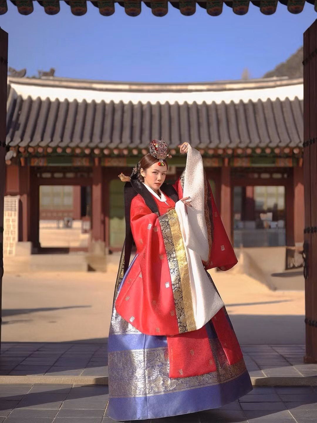 Trong một bức ảnh khác, nữ ca sĩ khẽ khép mắt, đặt tay lên cổ tay áo như đang sống trọn trong không khí cổ kính của hoàng cung. Tổng thể tạo nên cảm giác thanh tao, mềm mại nhưng đầy khí chất.