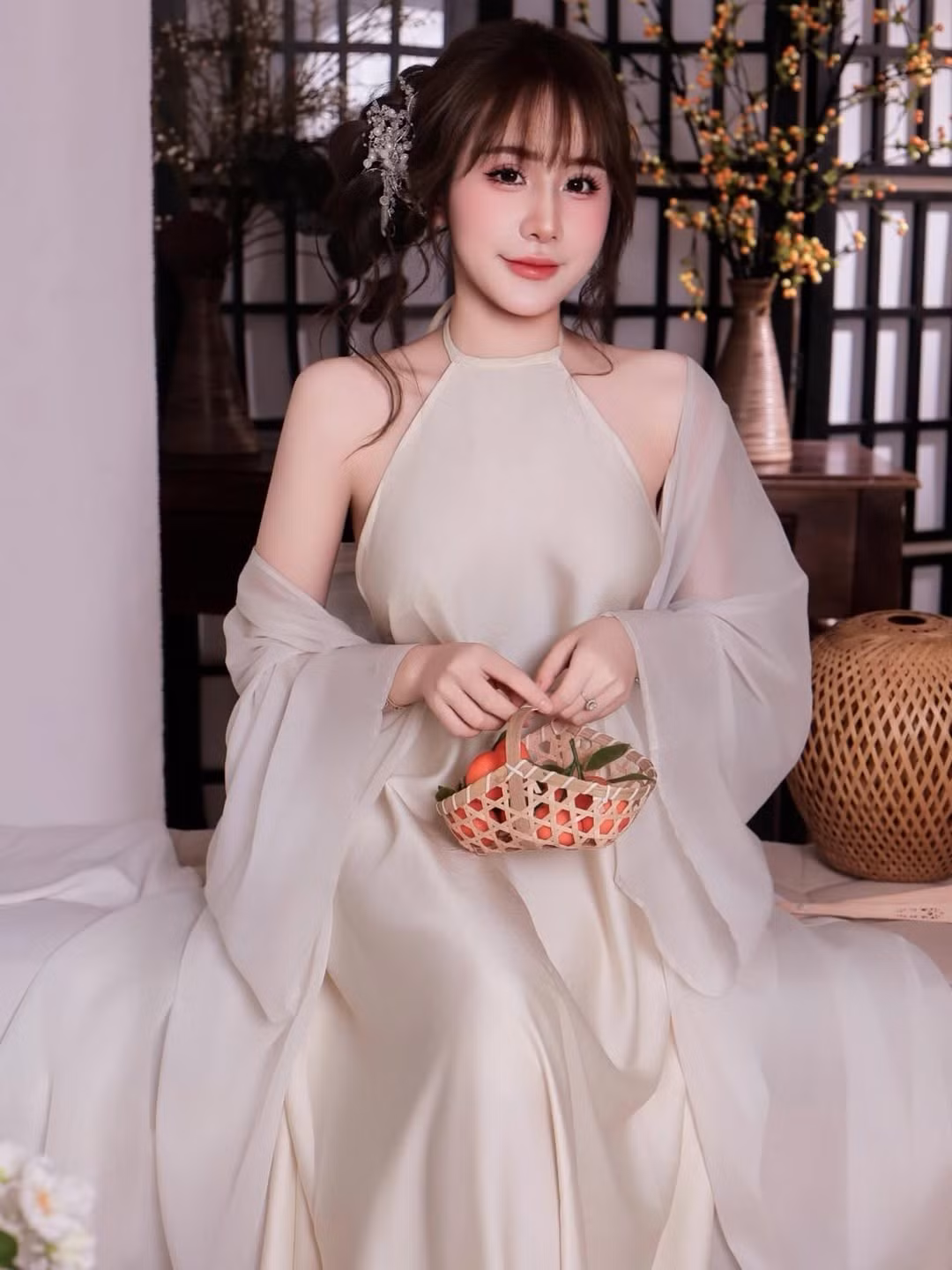 Trong khung cảnh ấy, từng ánh nhìn, cử chỉ cầm quạt hay nâng nhẹ giỏ mây đựng trái cây của Tuyết Anh đều toát lên nét duyên dáng rất riêng.