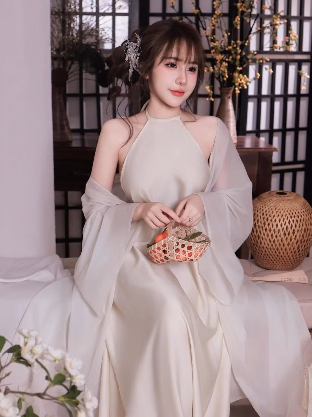 Kiểu tóc buộc thấp điểm xuyết phụ kiện ánh bạc cùng layout makeup trong veo, nhấn vào đôi mắt to tròn và làn môi hồng tự nhiên, mang lại cho cô vẻ đẹp mong manh như “nàng thơ” bước ra từ tranh vẽ.