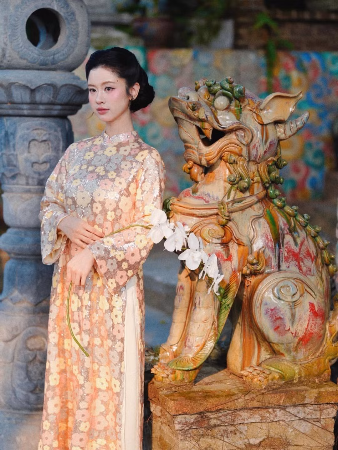 Cách tạo kiểu tóc búi gọn gàng cùng lớp trang điểm trong trẻo giúp gương mặt nàng 'hot girl tạp hóa' thêm rạng rỡ, đường nét hài hòa và làn da mịn màng.