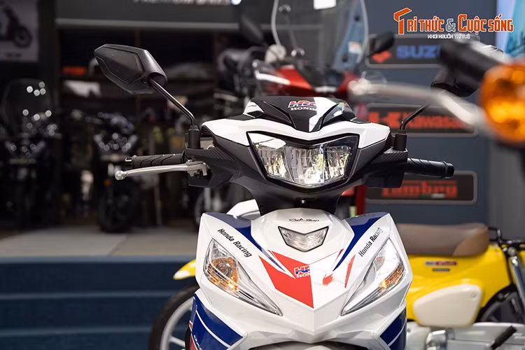 Về ngoại hình, Honda Dash 125 HRC 2025 sở hữu kiểu dáng thiết kế đậm chất thể thao và khí động học cao. Tổng thể "dàn áo" bao bọc thân xe được tạo dáng bằng những đường gân góc cạnh, liên kết liền lạc các chi tiết. Riêng phần đầu xe có thêm ốp mặt nạ chắn gió, đặt ngay trên cụm đèn pha LED.