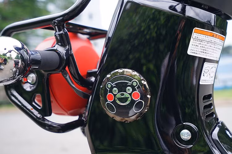 Đi kèm với đó là các chi tiết màu đỏ thuần ở xung quanh cụm đèn trước, hai bên ốp hông và cả một dải viền của yên xe hai màu. Ngoài ra, logo Kumamon cũng được đặt ở nhiều vị trí trên xe, bao gồm cả chìa khóa.