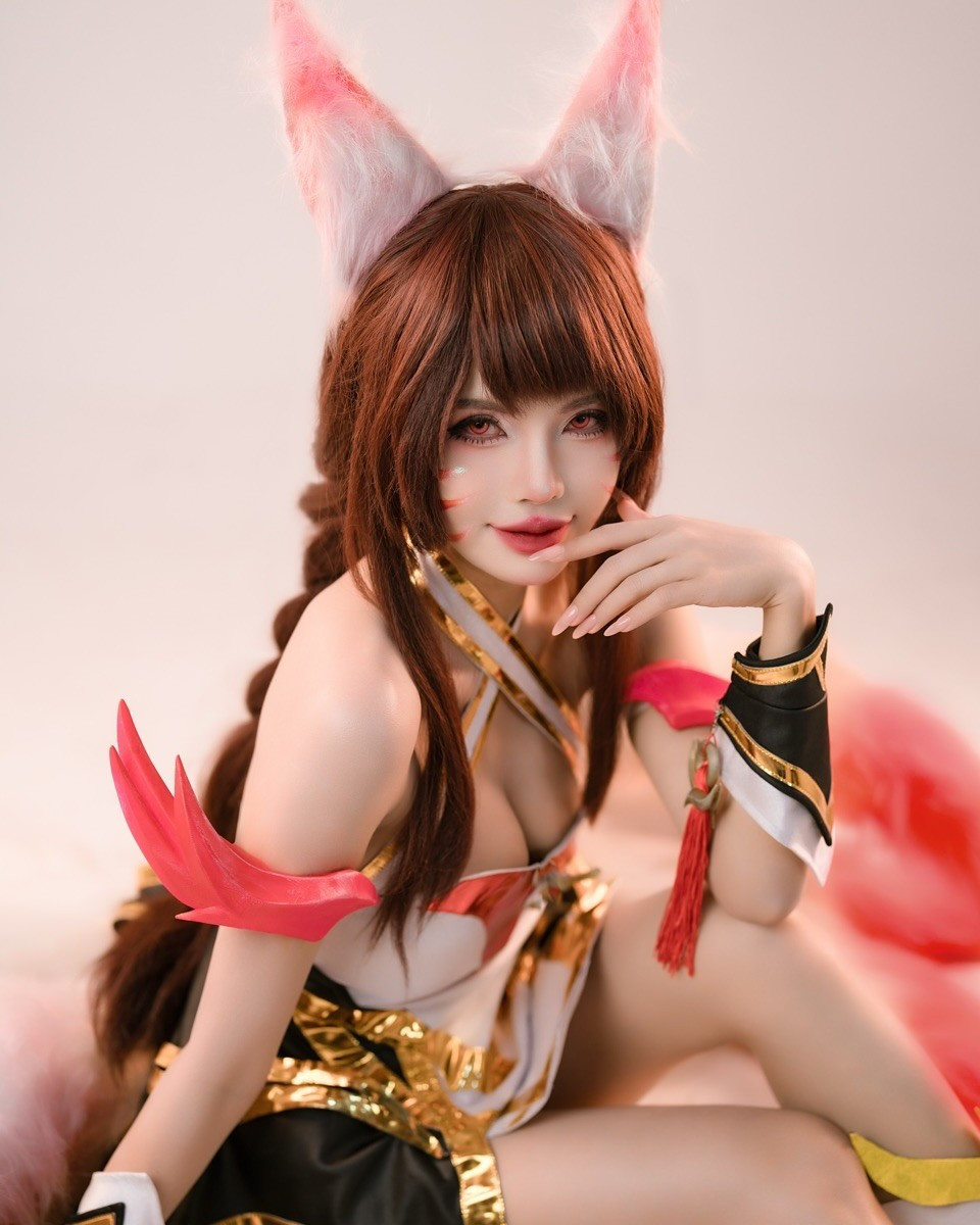 Điểm nhấn đắt giá của bộ ảnh chính là chín chiếc đuôi hồ ly bằng lông vũ cỡ lớn, xòe rộng màu trắng hồng vô cùng nổi bật, tạo nên một bối cảnh hoành tráng và huyền ảo.