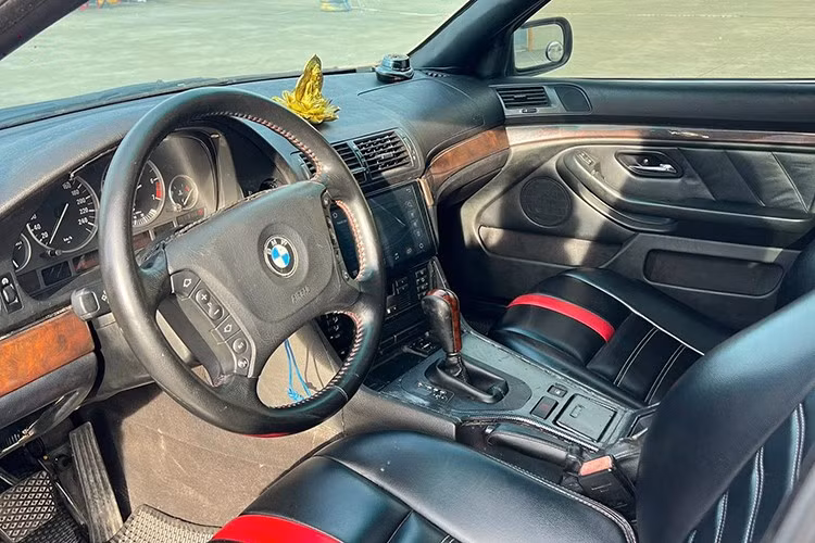 Khoang cabin của chiếc BMW 525i 2024 này sử dụng tông màu đen kết hợp ốp gỗ sáng, chưa xuất hiện nhiều dấu hiệu hư hỏng. Tuy nhiên, do hệ thống giải trí nguyên bản lỗi thời, chủ cũ đã lắp thêm một mà hình mới cỡ lơn thay cho màn hình trung tâm nguyên bản.