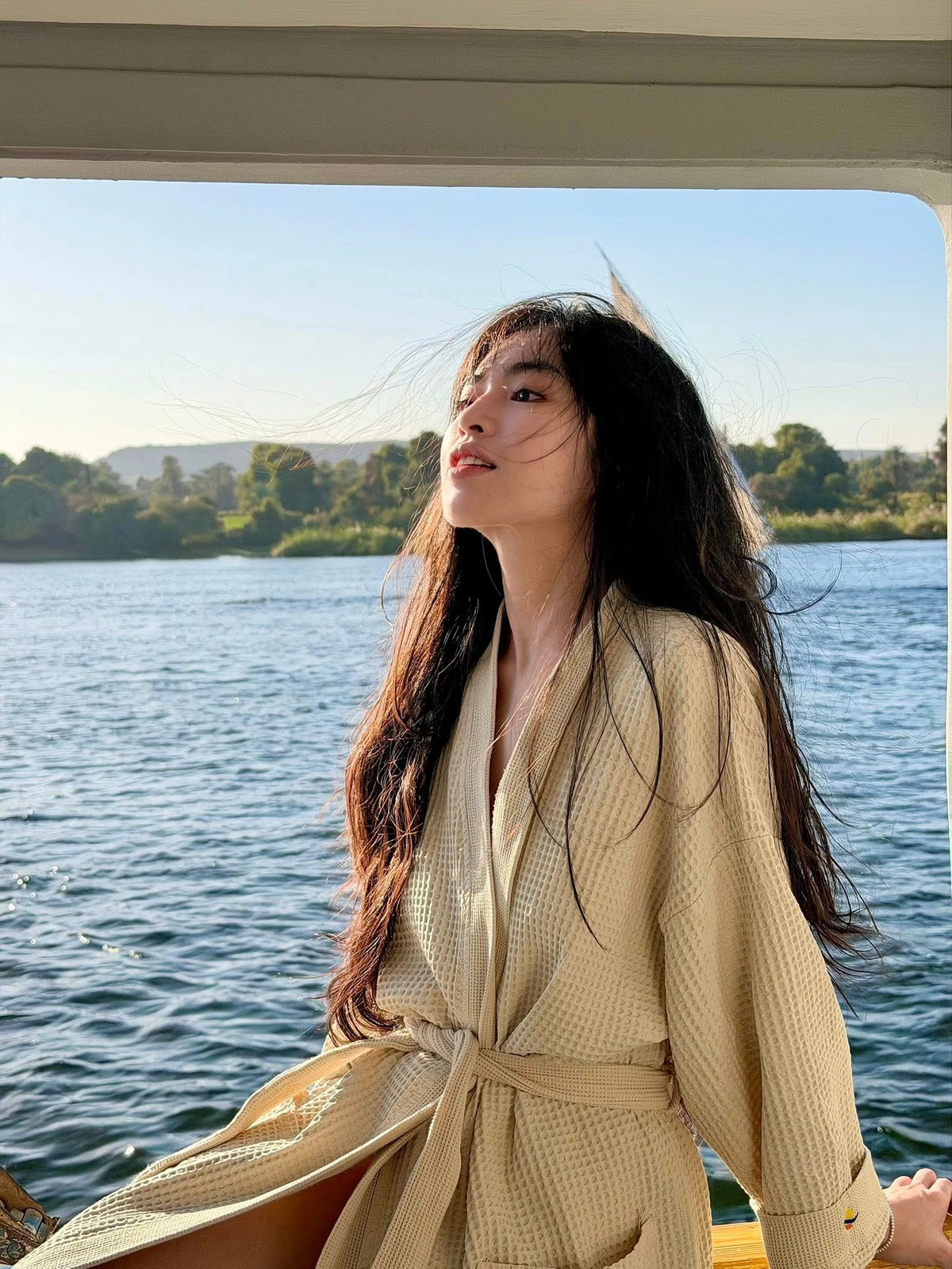 Biểu cảm thư thái, ánh nhìn xa xăm của cô gợi lên cảm giác tự do, an yên – đúng tinh thần của một chuyến đi để tận hưởng và tái tạo năng lượng.