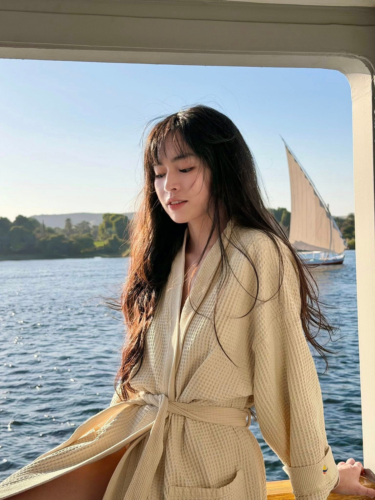 Không cần tạo dáng cầu kỳ, chỉ với những khoảnh khắc ngồi tựa lan can, khẽ ngẩng mặt đón nắng hay đưa tay cảm nhận làn gió sông Nile, Đỗ Khánh Vân đã mang đến loạt hình ảnh đầy chất điện ảnh.