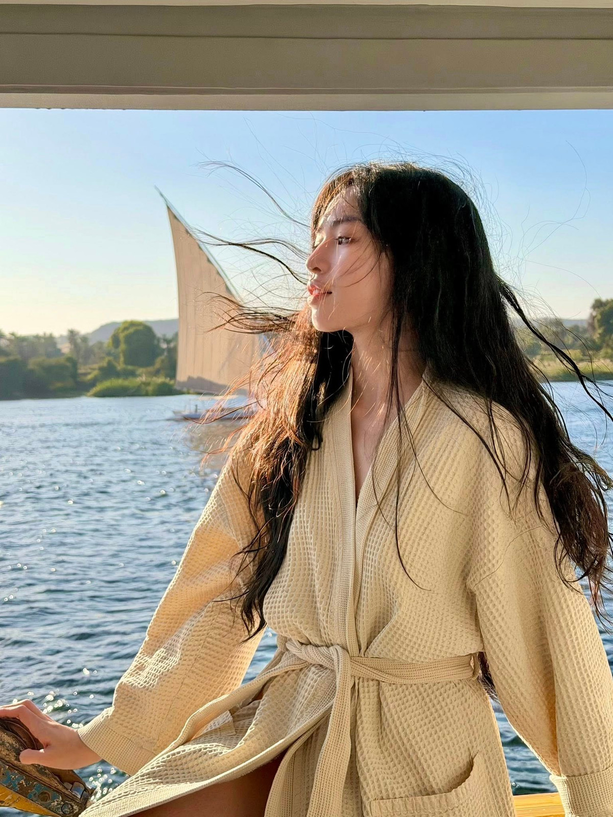 Kiểu trang phục này không chỉ tôn lên đôi chân thon dài mà còn giúp cô ghi điểm bởi vẻ đẹp thanh lịch, tinh tế, đúng chất nghỉ dưỡng sang trọng. Dưới ánh nắng tự nhiên, làn da sáng cùng mái tóc dài buông xõa theo gió càng làm nổi bật vẻ nữ tính, dịu dàng của nữ diễn viên.