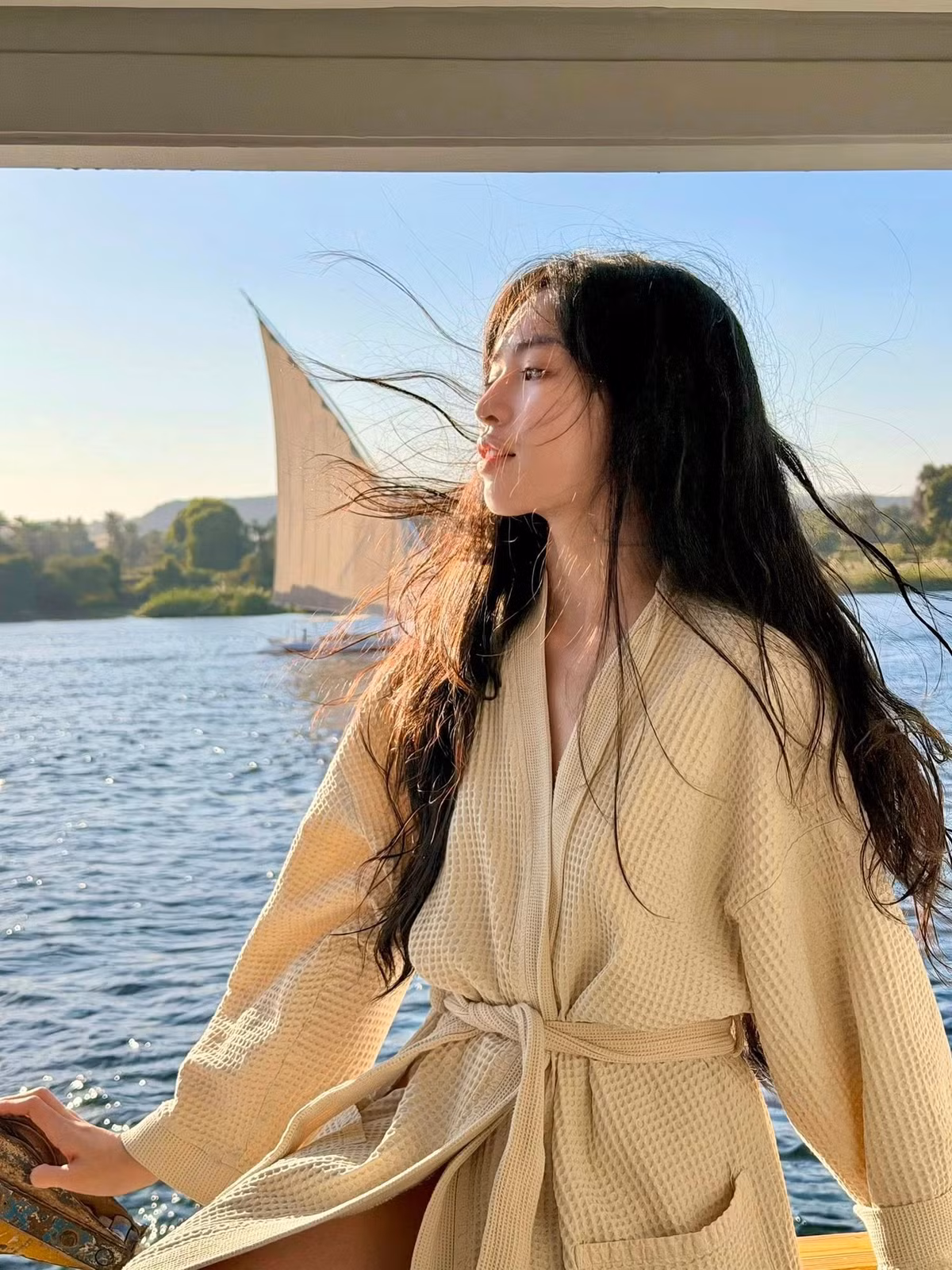 Kiểu trang phục này không chỉ tôn lên đôi chân thon dài mà còn giúp cô ghi điểm bởi vẻ đẹp thanh lịch, tinh tế, đúng chất nghỉ dưỡng sang trọng. Dưới ánh nắng tự nhiên, làn da sáng cùng mái tóc dài buông xõa theo gió càng làm nổi bật vẻ nữ tính, dịu dàng của nữ diễn viên.