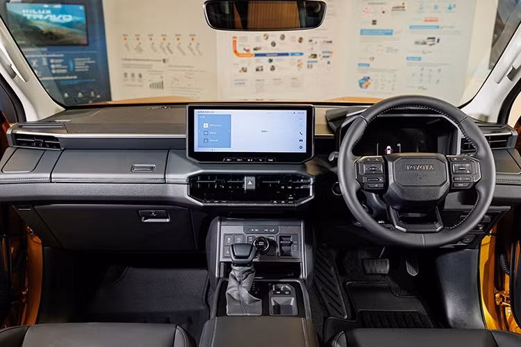 Bên trong, nội thất Hilux 2026 mang thiết kế hiện đại tương tự dòng Land Cruiser, nổi bật với bảng táp-lô trải ngang và cụm màn hình kép 12,3 inch: một cho hệ thống giải trí trung tâm và một cho cụm đồng hồ kỹ thuật số trước vô-lăng.