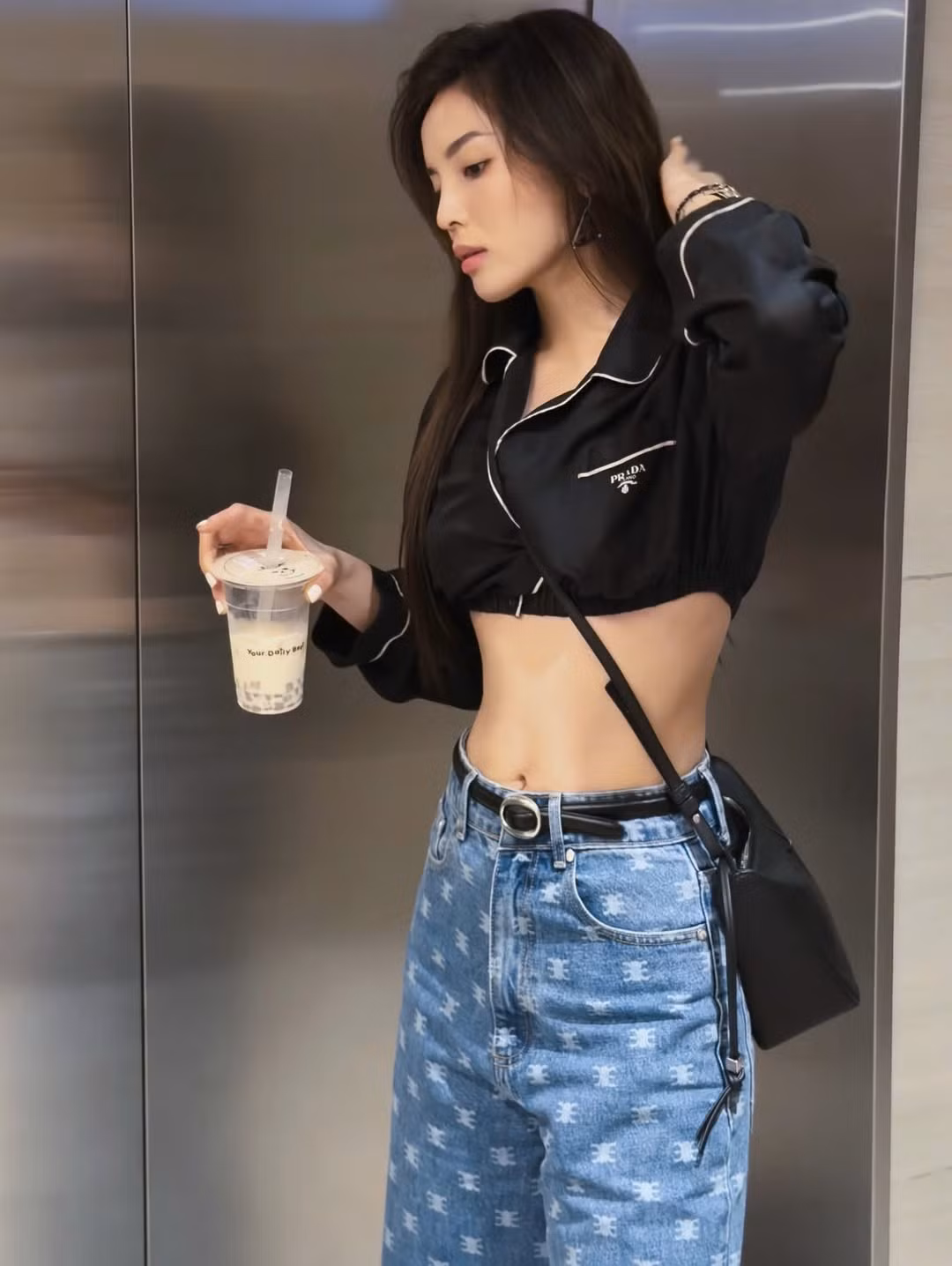 Kỳ Duyên phối cùng quần jeans ống rộng họa tiết đặc trưng, đậm chất street style, kết hợp túi đeo chéo nhỏ gọn và sandals tối màu. Tổng thể trang phục vừa tối giản vừa hiện đại, mang lại vibe trẻ trung nhưng không kém phần thời thượng.