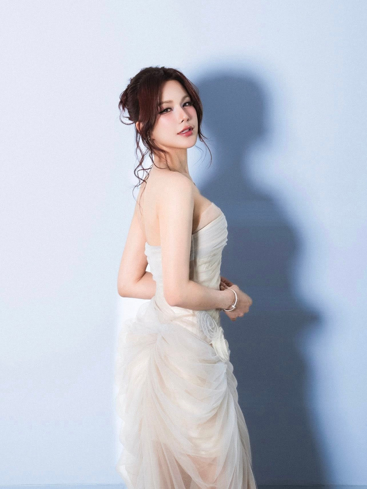 Phom váy ôm sát khéo léo tôn lên vóc dáng thon gọn, trong khi những nếp draping mềm mại mang lại cảm giác nữ tính, sang trọng. Gam màu trung tính giúp tổng thể thêm phần tinh tế, không phô trương nhưng đủ để thu hút mọi ánh nhìn.