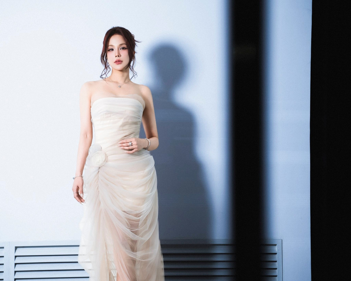 Gương mặt thanh tú, làn da mịn màng cùng lối trang điểm trong veo làm nổi bật đôi mắt sâu và nụ cười nhẹ đầy cảm xúc.