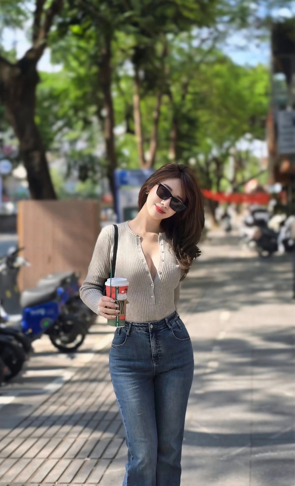 Phụ kiện đi kèm như túi xách nhỏ, kính râm và ly cà phê trên tay càng khiến hình ảnh của Hà Kim thêm phần thời thượng, hiện đại.