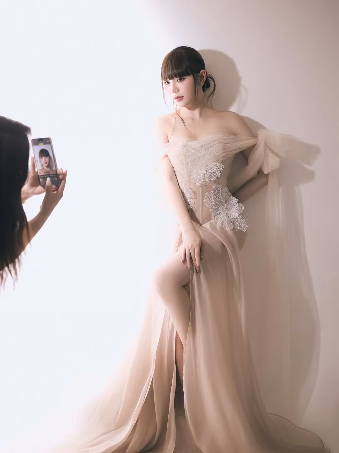 Điểm nhấn của bộ trang phục là những mảng hoa ren trắng được đính kết tinh xảo trên phần thân áo, tạo hiệu ứng nửa kín nửa hở vô cùng cuốn hút.