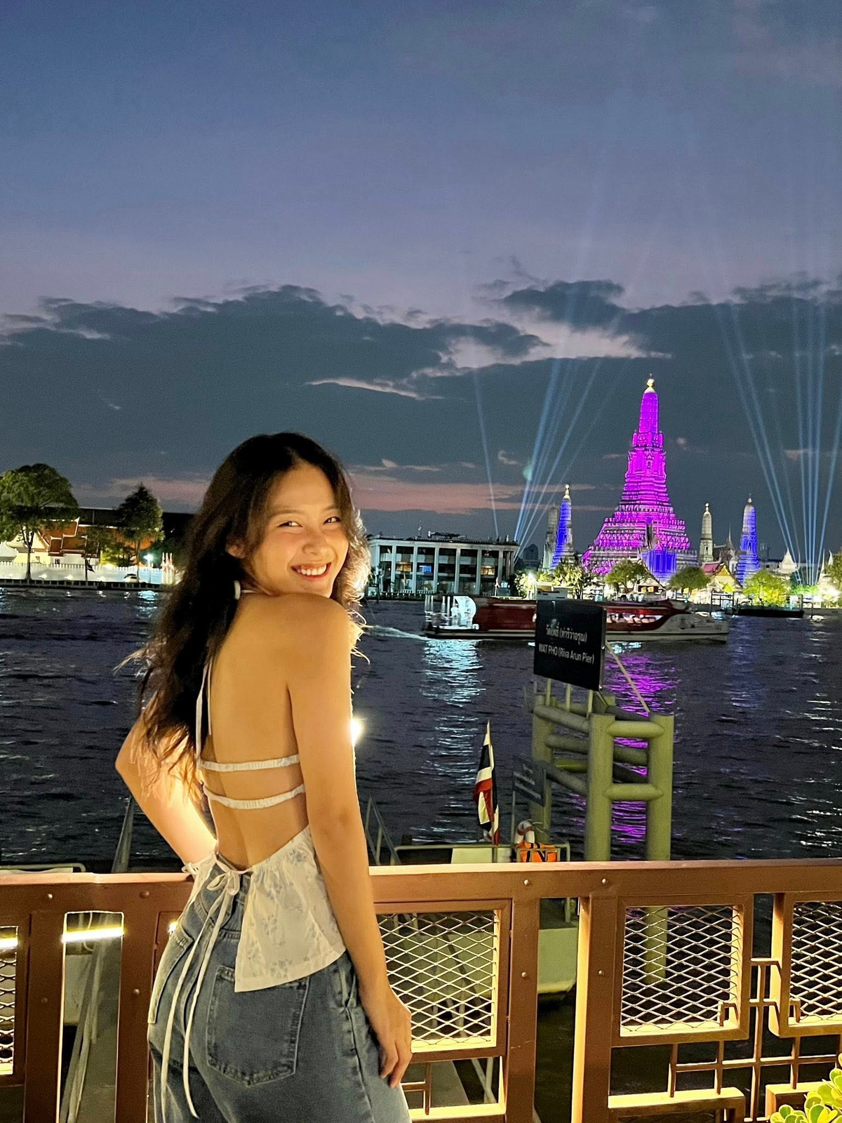 Không cầu kỳ trang phục hay tạo dáng kiểu mẫu, Khả Ngân vẫn ghi điểm tuyệt đối nhờ nhan sắc tươi tắn, phong thái tự nhiên và nụ cười rạng rỡ giữa khung cảnh sông nước, phố đêm Bangkok rực rỡ ánh đèn.