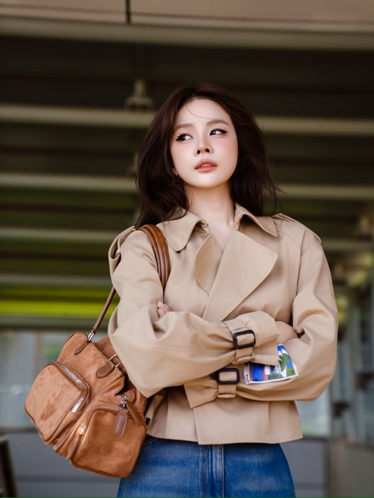 Trong loạt ảnh đính kèm, DJ Mie xuất hiện với trang phục mang tông màu trung tính, nổi bật là chiếc áo khoác dáng trench coat được thắt eo gọn gàng, kết hợp cùng quần jeans ống suông và phụ kiện túi da nâu cổ điển.