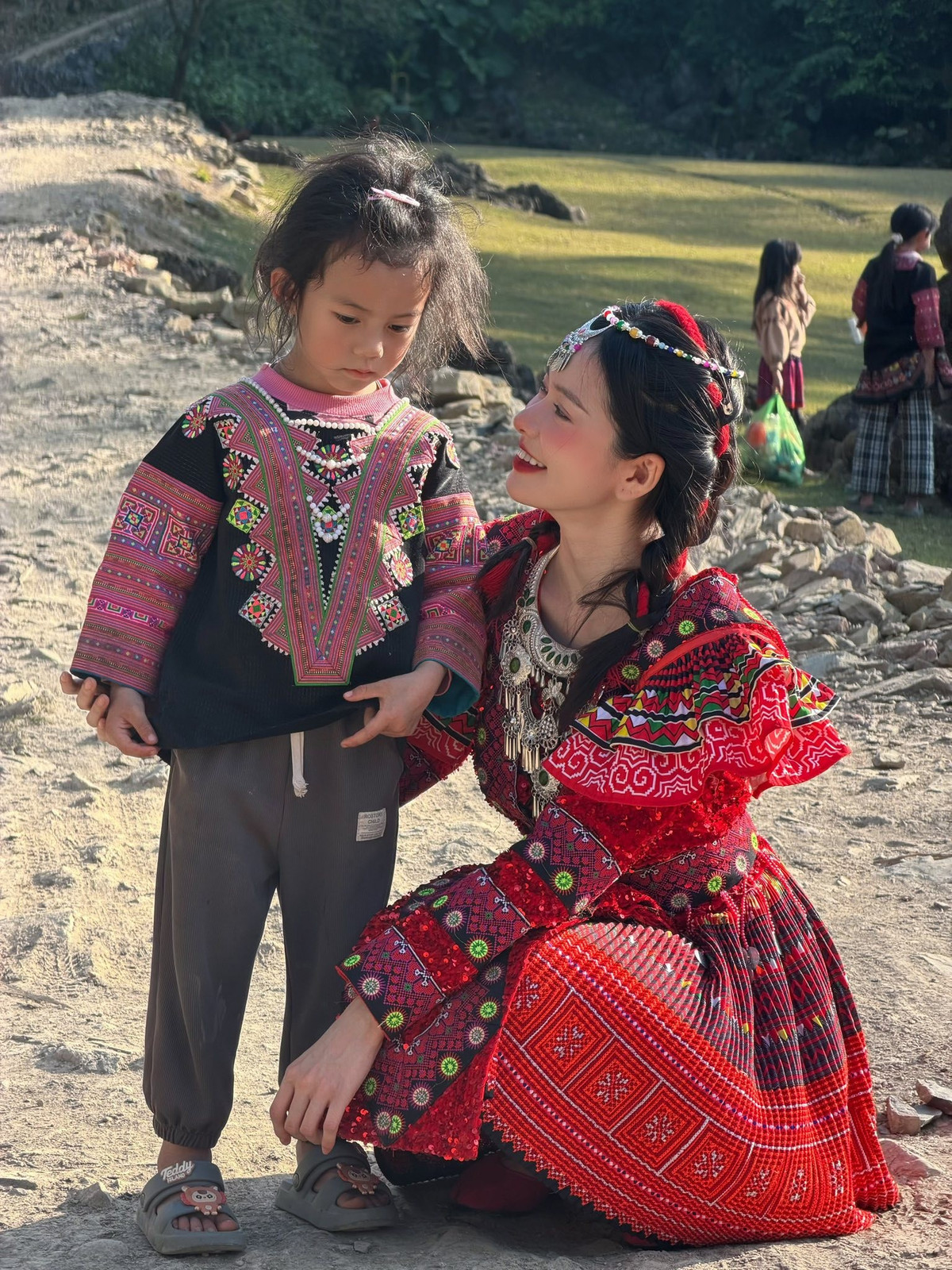 Giữa không gian núi đá, rừng xanh và ánh nắng dịu nhẹ đầu năm, Đỗ Yên Đan xuất hiện với thần thái rạng rỡ, gương mặt trang điểm nhẹ nhàng nhưng nổi bật. Kiểu tóc tết gọn gàng, phụ kiện cài đầu truyền thống càng làm tôn lên vẻ đẹp thuần khiết, trong veo của cô nàng.