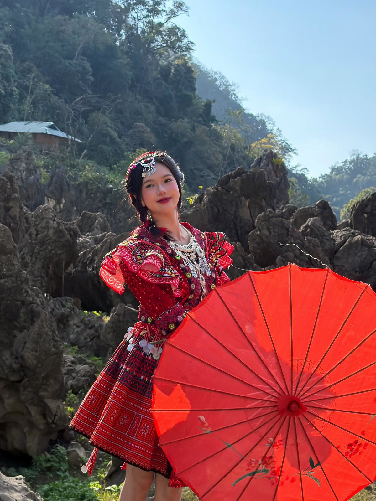 Những đường thêu tinh xảo, họa tiết hình học bắt mắt cùng chiếc ô giấy đỏ tạo điểm nhấn, giúp tổng thể hình ảnh vừa mang đậm bản sắc văn hóa, vừa toát lên nét trẻ trung, hiện đại.