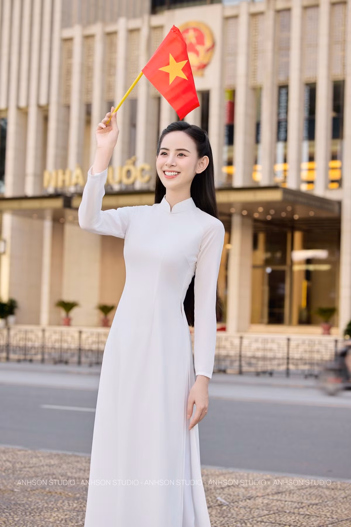 Chiếc áo dài Hương Liên diện có chất liệu lụa mềm mại, tạo độ rủ nhẹ nhàng theo từng chuyển động. Họa tiết chìm tinh tế trên nền vải trắng giúp tổng thể không bị đơn điệu mà vẫn giữ được sự trang nhã. Phần cổ cao, tay dài và phom dáng ôm vừa phải tôn lên vóc dáng thanh mảnh, đồng thời vẫn giữ được sự kín đáo, đúng chuẩn mực của áo dài truyền thống Việt Nam.