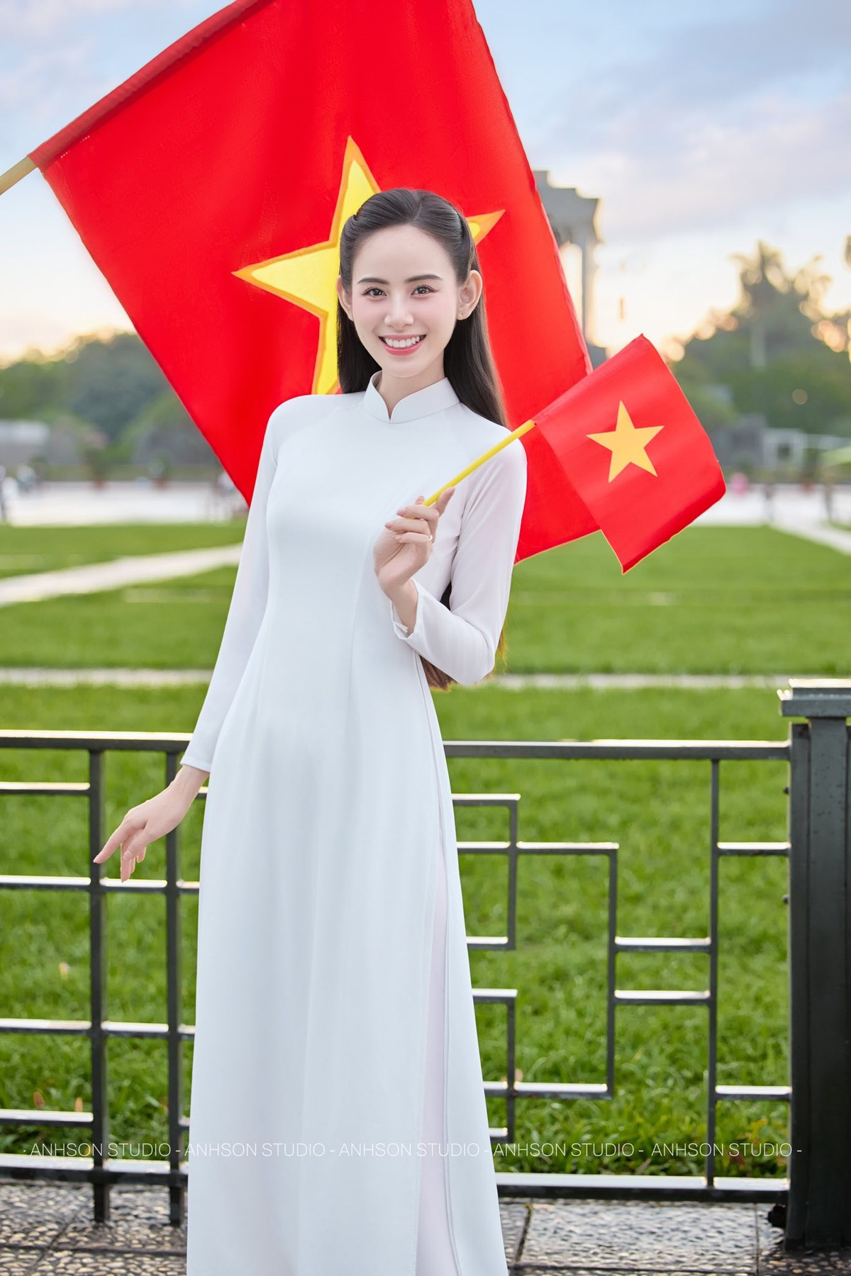 Điểm nổi bật trong loạt ảnh lần này chính là thần thái của Hương Liên. Không tạo dáng cầu kỳ, cô chỉ nhẹ nhàng đứng bên nhành hoa, khẽ nghiêng đầu hay mỉm cười trước ống kính cũng đủ khiến khung hình trở nên mềm mại. Ánh mắt trong trẻo, nụ cười tươi nhưng không quá rực rỡ, tất cả góp phần làm nổi bật vẻ đẹp tự nhiên, đúng tinh thần của tà áo dài truyền thống.