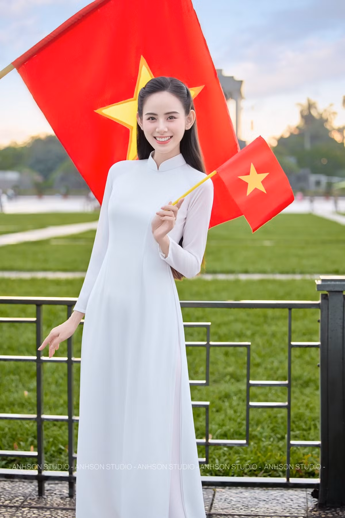 Điểm nổi bật trong loạt ảnh lần này chính là thần thái của Hương Liên. Không tạo dáng cầu kỳ, cô chỉ nhẹ nhàng đứng bên nhành hoa, khẽ nghiêng đầu hay mỉm cười trước ống kính cũng đủ khiến khung hình trở nên mềm mại. Ánh mắt trong trẻo, nụ cười tươi nhưng không quá rực rỡ, tất cả góp phần làm nổi bật vẻ đẹp tự nhiên, đúng tinh thần của tà áo dài truyền thống.