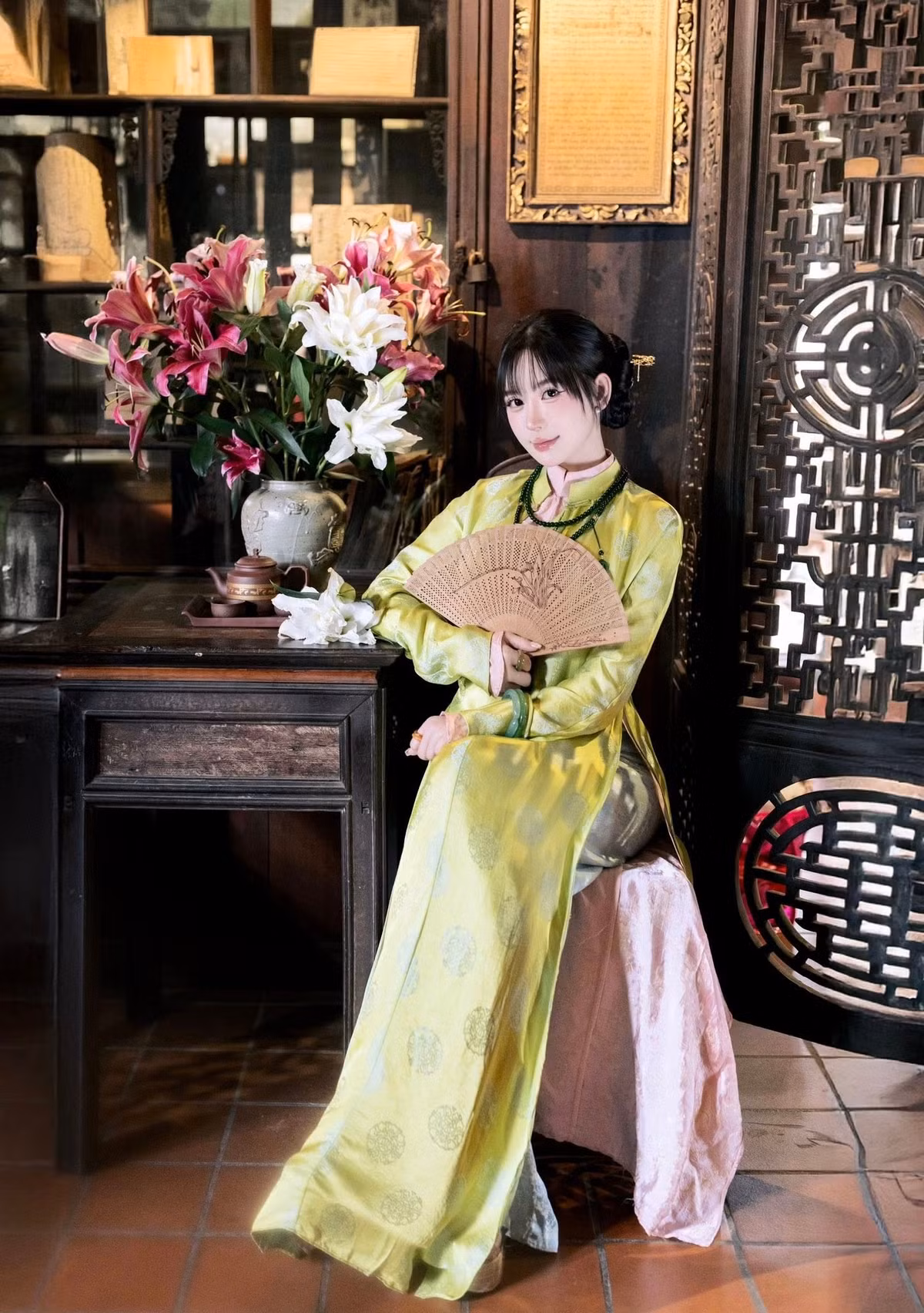 Trong không gian ấy, hình ảnh Vân Tiny khoan thai tựa lan can gỗ, ngồi bên bậc thềm hay lặng lẽ bên bình hoa trắng càng làm tăng cảm giác trầm lắng, sang trọng.