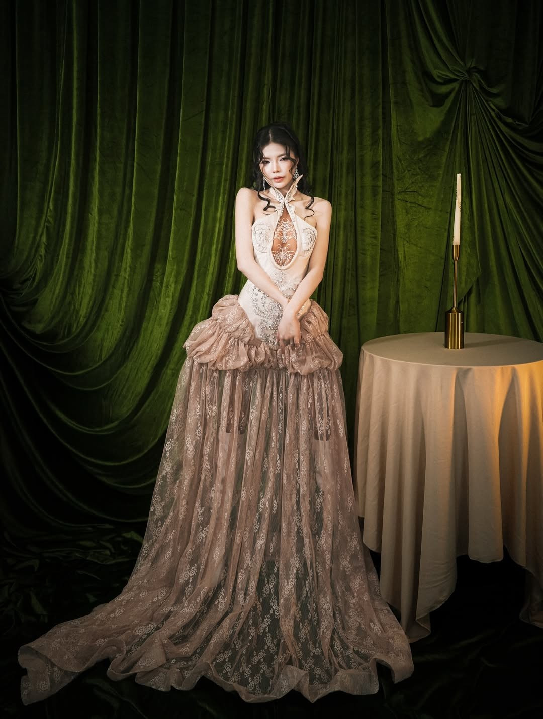 Thiết kế cổ yếm cùng đường khoét vừa đủ tạo cảm giác gợi cảm mà không phô trương, giúp Mai Dora tôn lên bờ vai thon, vòng eo nhỏ gọn và làn da trắng mịn. Phần chân váy xếp lớp bay nhẹ theo từng chuyển động khiến tổng thể trở nên lãng mạn, đúng tinh thần lễ hội cuối năm.