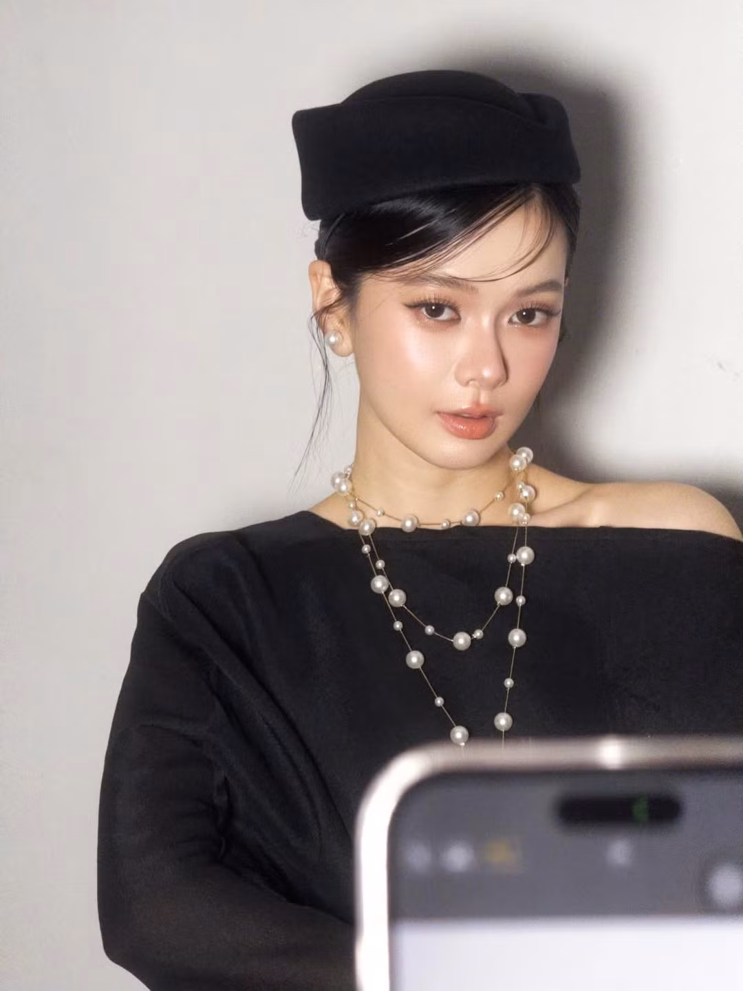 Trong loạt ảnh, Đỗ Yên Đan diện trang phục đen tối giản nhưng tinh tế, kết hợp cùng mũ beret và chuỗi vòng ngọc trai sang trọng. Phong cách trang điểm của cô nhẹ nhàng nhưng vô cùng sắc sảo, làm nổi bật từng đường nét hài hòa trên gương mặt.