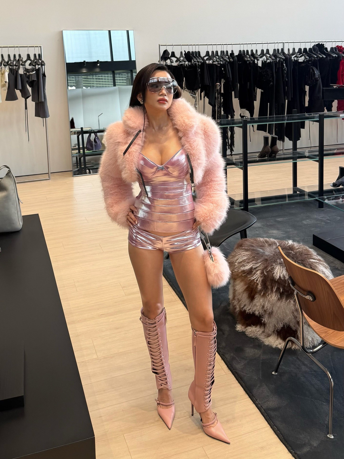 Xuất hiện tại một không gian thời trang cao cấp, Sĩ Thanh lựa chọn bộ trang phục gồm áo corset ánh kim kết hợp quần short ngắn, khoác ngoài là áo lông hồng phấn nổi bật.